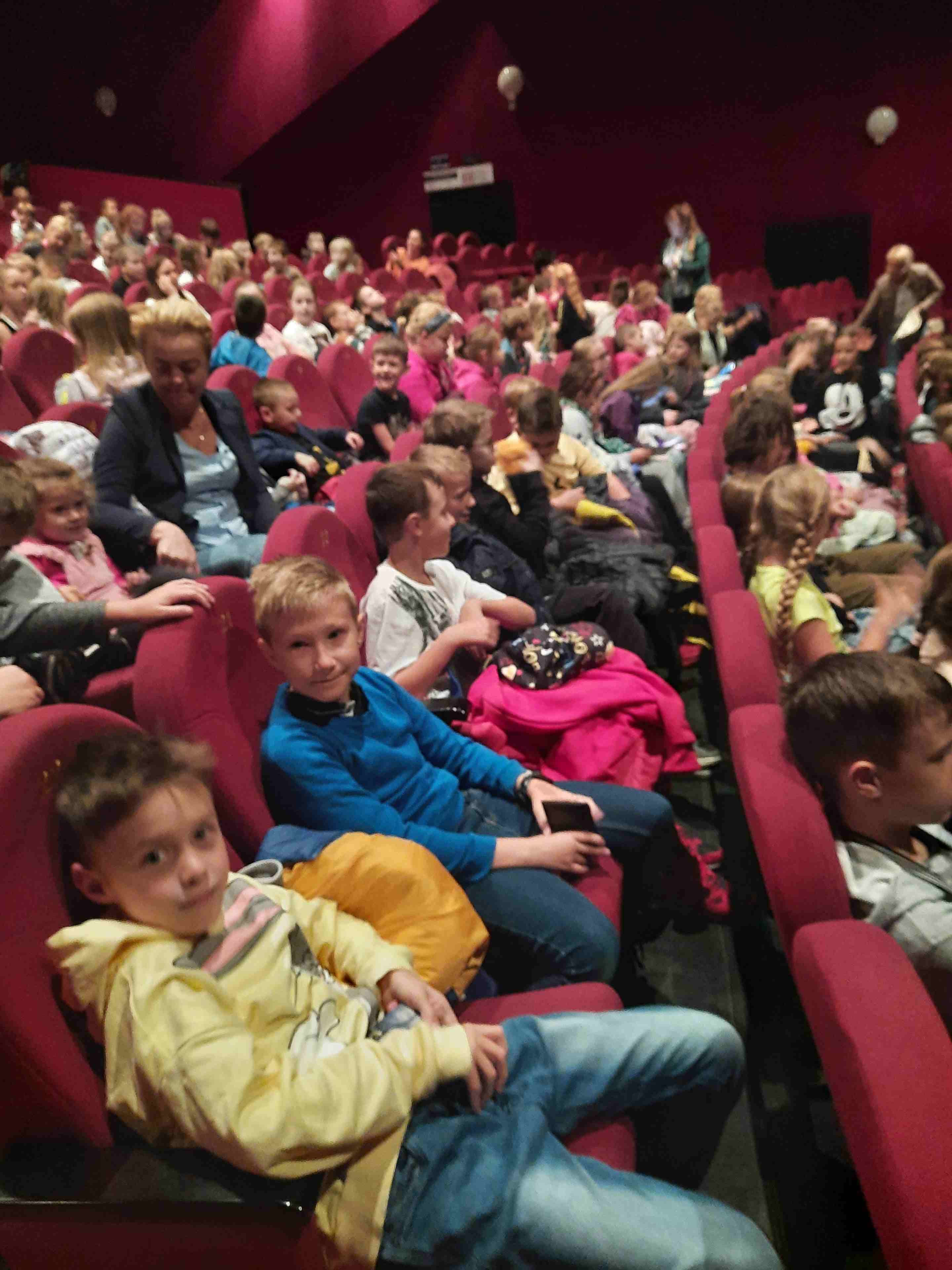Dzieci siedzą na widowni w kinie