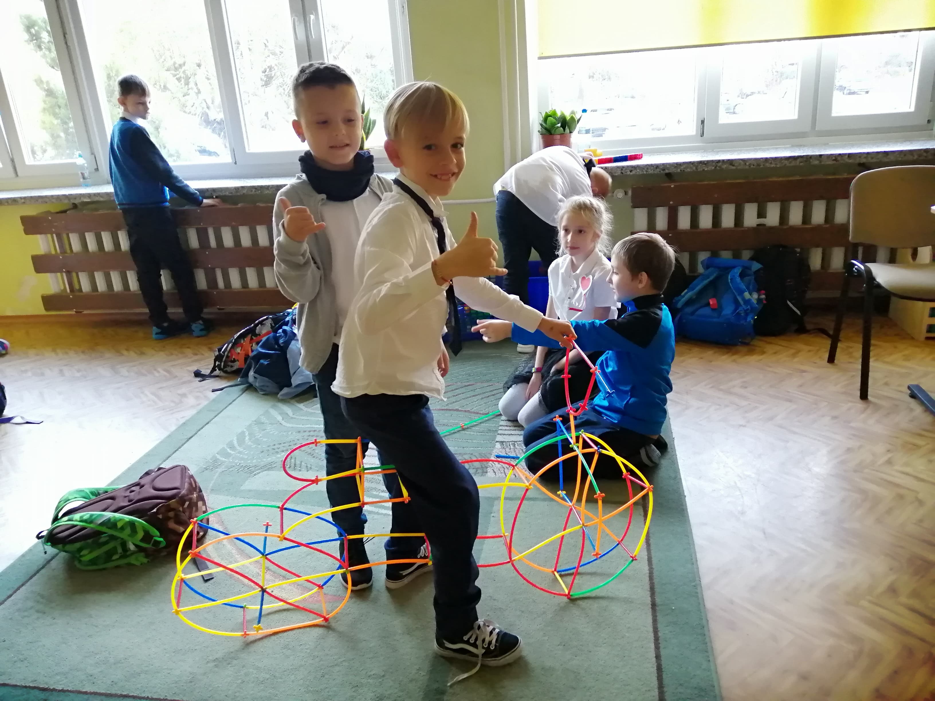 Dwóch chłopców prezentuje zbudowany przez siebie z klocków rower