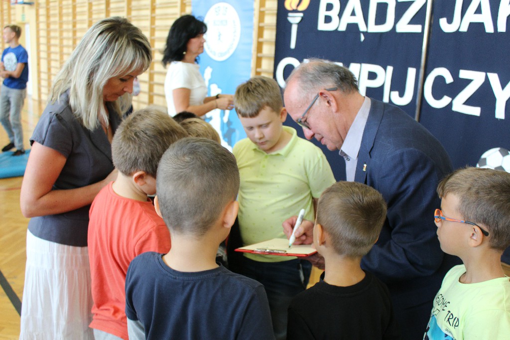 Mieczysław Nowicki rozdaje autografy dzieciom na sali gimnastycznej